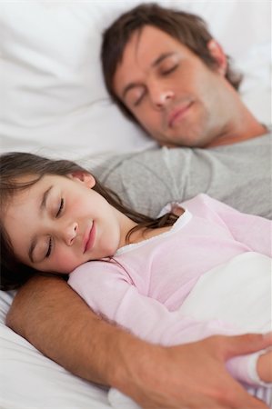 father at bed being hug - Portrait of a father sleeping with his daughter in a bedroom Stock Photo - Budget Royalty-Free & Subscription, Code: 400-05749814