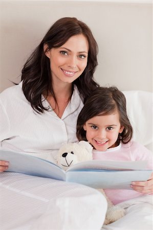 Portrait of a happy mother reading a story to her daughter in a bedroom Stock Photo - Budget Royalty-Free & Subscription, Code: 400-05749827
