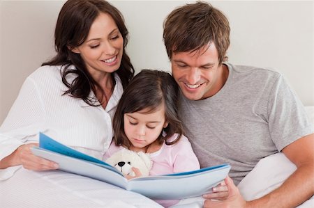 simsearch:400-04193532,k - Happy parents reading a story to their daughter in a bedroom Stock Photo - Budget Royalty-Free & Subscription, Code: 400-05749830