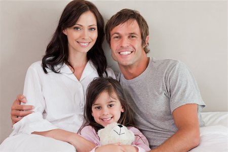 simsearch:400-05749479,k - Parents posing with their daughter in a bedroom Foto de stock - Royalty-Free Super Valor e Assinatura, Número: 400-05749833