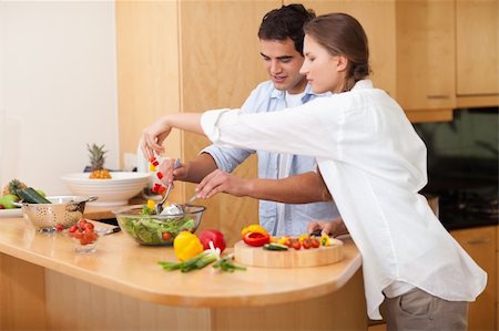 simsearch:400-04162443,k - Happy couple preparing a salad in their kitchen Fotografie stock - Microstock e Abbonamento, Codice: 400-05740092