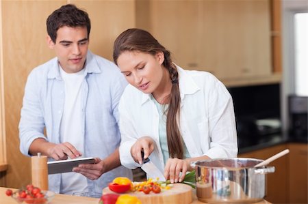 Modern couple using a tablet computer to cook in their kitchen Stock Photo - Budget Royalty-Free & Subscription, Code: 400-05740114