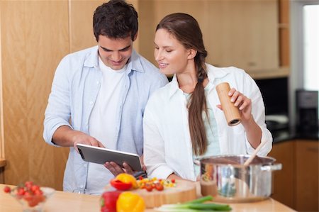In love couple using a tablet computer to cook in their kitchen Stock Photo - Budget Royalty-Free & Subscription, Code: 400-05740116
