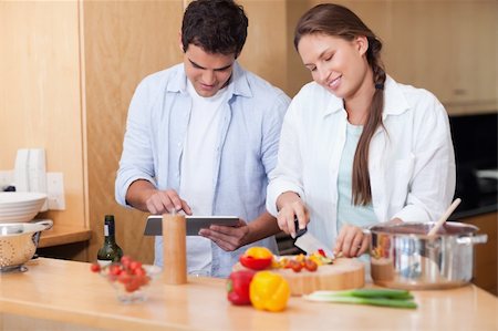 Couple using a tablet computer to cook in their kitchen Stock Photo - Budget Royalty-Free & Subscription, Code: 400-05740112