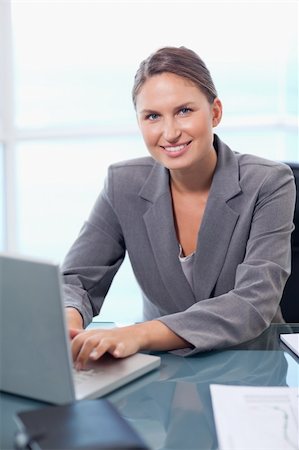 simsearch:400-04894274,k - Portrait of a smiling businesswoman working with a laptop in her office Stock Photo - Budget Royalty-Free & Subscription, Code: 400-05740220