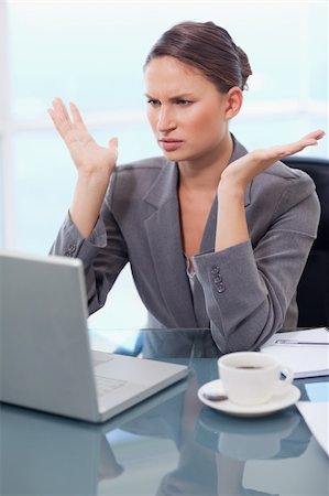 simsearch:400-08554629,k - Portrait of an upset businesswoman working with a notebook in her office Fotografie stock - Microstock e Abbonamento, Codice: 400-05740244