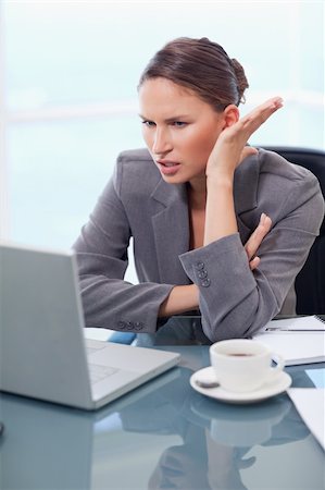 simsearch:400-08554629,k - Portrait of an angry businesswoman working with a notebook in her office Fotografie stock - Microstock e Abbonamento, Codice: 400-05740243