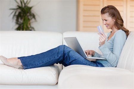 electronic banking tablet - Young woman booking flight online on her sofa Stock Photo - Budget Royalty-Free & Subscription, Code: 400-05740357