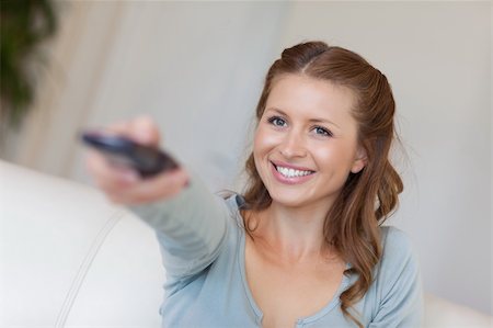 simsearch:400-05748048,k - Smiling young woman watching tv on her couch Stockbilder - Microstock & Abonnement, Bildnummer: 400-05740814