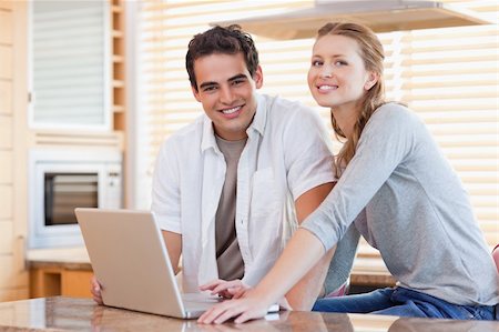simsearch:400-05749531,k - Young couple with notebook in the kitchen Stock Photo - Budget Royalty-Free & Subscription, Code: 400-05741104