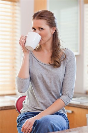 simsearch:400-05749531,k - Young woman drinking coffee in the kitchen Stock Photo - Budget Royalty-Free & Subscription, Code: 400-05741116