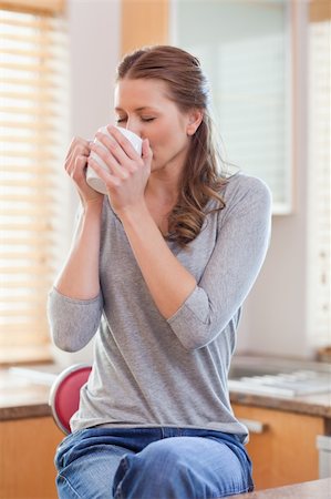 simsearch:400-05749531,k - Young woman relaxing with coffee in the kitchen Stock Photo - Budget Royalty-Free & Subscription, Code: 400-05741117