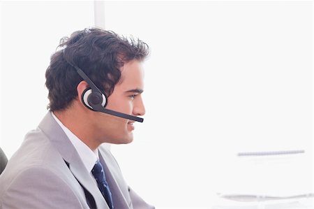 simsearch:400-06108986,k - Side view of young businessman with headset on Stock Photo - Budget Royalty-Free & Subscription, Code: 400-05741146