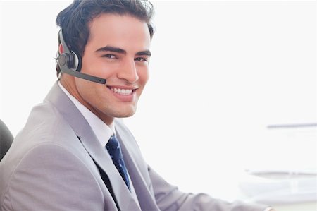 simsearch:400-06108986,k - Side view of smiling young businessman with headset on Stock Photo - Budget Royalty-Free & Subscription, Code: 400-05741147