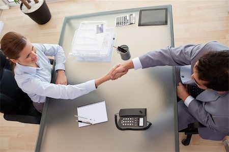 Above view of young consultant shaking hands with customer Foto de stock - Super Valor sin royalties y Suscripción, Código: 400-05741169