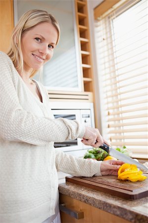 simsearch:400-05748090,k - Smiling woman slicing yellow pepper bell Foto de stock - Super Valor sin royalties y Suscripción, Código: 400-05741477