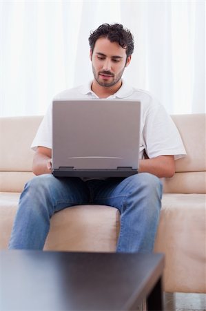 simsearch:400-05715661,k - Portrait of a man using a laptop in his living room Photographie de stock - Aubaine LD & Abonnement, Code: 400-05741525