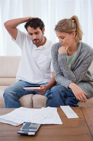 Portrait of a couple looking at their bills in their living room Stock Photo - Budget Royalty-Free & Subscription, Code: 400-05741557