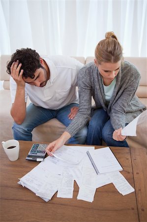 Portrait of a depressed couple doing their accounting in their living room Stock Photo - Budget Royalty-Free & Subscription, Code: 400-05741566