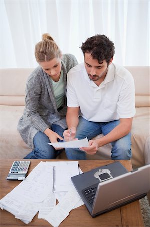 Portrait of a couple doing their accounting with a notebook in their living room Stock Photo - Budget Royalty-Free & Subscription, Code: 400-05741569