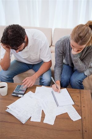Portrait of a couple doing their accounting in their living room Stock Photo - Budget Royalty-Free & Subscription, Code: 400-05741562