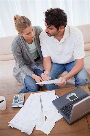 Portrait of a young couple doing their accounting with a notebook in their living room Stock Photo - Budget Royalty-Free & Subscription, Code: 400-05741570