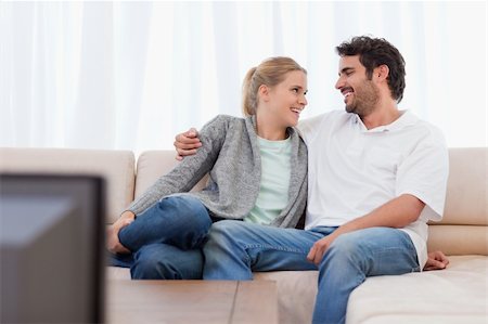 simsearch:400-05748048,k - Smiling couple watching TV in their living room Stockbilder - Microstock & Abonnement, Bildnummer: 400-05741587