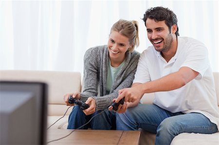 simsearch:400-04878558,k - Couple playing video games in their living room Stock Photo - Budget Royalty-Free & Subscription, Code: 400-05741589