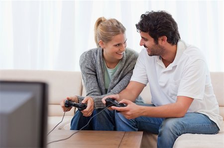 Happy couple playing video games in their living room Stock Photo - Budget Royalty-Free & Subscription, Code: 400-05741590