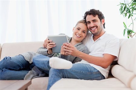 simsearch:400-04663577,k - Happy young couple using a tablet computer in their living room Stock Photo - Budget Royalty-Free & Subscription, Code: 400-05741792
