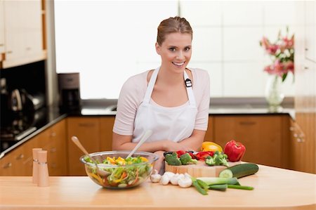 simsearch:400-05357733,k - Young woman cooking in her kitchen Fotografie stock - Microstock e Abbonamento, Codice: 400-05741819