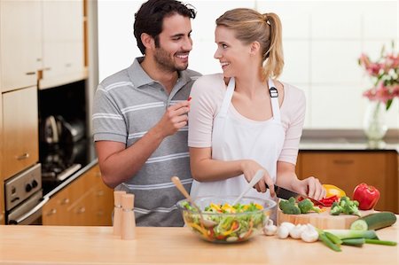 simsearch:400-04162443,k - Young couple slicing vegetables in their living room Fotografie stock - Microstock e Abbonamento, Codice: 400-05741821