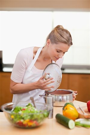 Portrait of a woman smelling in a sauce pan in her kitchen Stock Photo - Budget Royalty-Free & Subscription, Code: 400-05741863