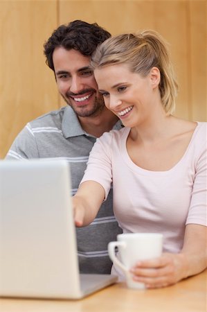 simsearch:400-04335902,k - Portrait of a couple using a notebook while having tea in their kitchen Stock Photo - Budget Royalty-Free & Subscription, Code: 400-05741875