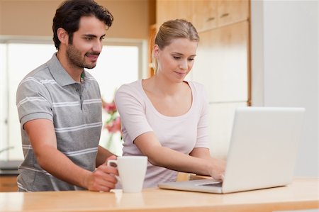 simsearch:400-05741872,k - Couple using a laptop while having coffee in their kitchen Stockbilder - Microstock & Abonnement, Bildnummer: 400-05741871