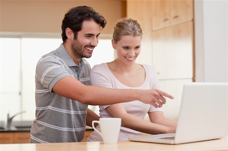 simsearch:400-05741872,k - Couple using a notebook while having coffee in their kitchen Stock Photo - Budget Royalty-Free & Subscription, Code: 400-05741872