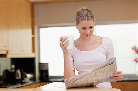 simsearch:400-04335902,k - Woman reading the news while having tea in her kitchen Stock Photo - Budget Royalty-Free & Subscription, Code: 400-05741898