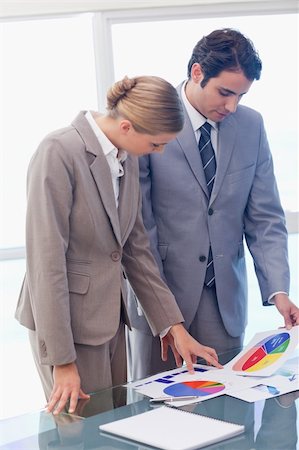 Portrait of young business people looking at statistics in a meeting room Stock Photo - Budget Royalty-Free & Subscription, Code: 400-05741992