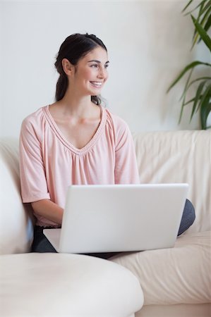 simsearch:400-05715528,k - Portrait of a smiling woman using a notebook in her living room Stock Photo - Budget Royalty-Free & Subscription, Code: 400-05742010