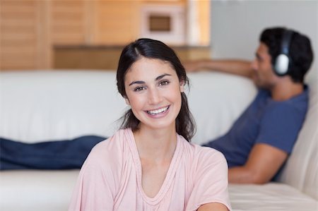 simsearch:400-04151970,k - Woman posing while her fiance is listening to music in their living room Fotografie stock - Microstock e Abbonamento, Codice: 400-05742073