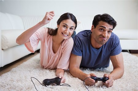 Woman beating her boyfriend while playing video games in their living room Stock Photo - Budget Royalty-Free & Subscription, Code: 400-05742103