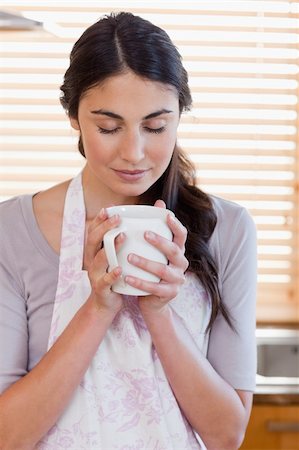simsearch:400-04335902,k - Portrait of a woman smelling a cup of coffee in her kitchen Stock Photo - Budget Royalty-Free & Subscription, Code: 400-05742714