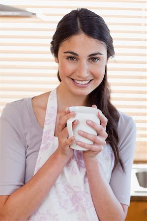 simsearch:400-04335902,k - Portrait of a woman holding a cup of tea in her kitchen Stock Photo - Budget Royalty-Free & Subscription, Code: 400-05742715