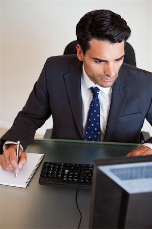 simsearch:400-05718341,k - Portrait of a serious businessman taking notes in his office Stock Photo - Budget Royalty-Free & Subscription, Code: 400-05742727