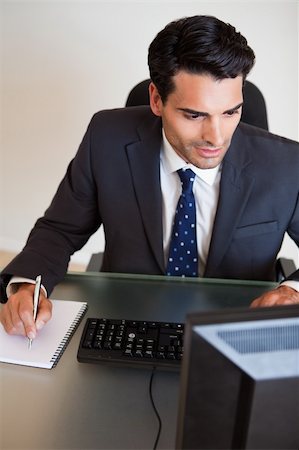 simsearch:400-05718341,k - Portrait of a focused businessman taking notes in his office Stock Photo - Budget Royalty-Free & Subscription, Code: 400-05742728