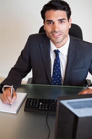 simsearch:400-05900668,k - Portrait of a handsome businessman taking notes in his office Stock Photo - Budget Royalty-Free & Subscription, Code: 400-05742729