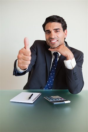 simsearch:400-04782141,k - Portrait of a young accountant with the thumb up in his office Stock Photo - Budget Royalty-Free & Subscription, Code: 400-05742744