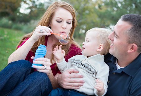 Attractive Young Parents Having Fun Blowing Bubbles with their Child Boy in the Park. Stock Photo - Budget Royalty-Free & Subscription, Code: 400-05743775