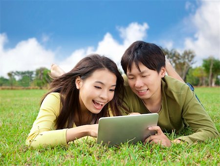 students tablets outside - young asian student using tablet computer while lying in the park Stock Photo - Budget Royalty-Free & Subscription, Code: 400-05754466