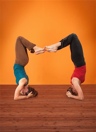 simsearch:400-04328141,k - Two women perform Vrisikasana yoga posture on a wooden mat Stock Photo - Budget Royalty-Free & Subscription, Code: 400-05754645